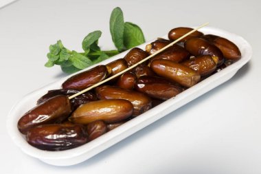 Hurmalar, plastik kutuya doldurulmuş, satılmaya hazır, beyaz arka plan. İş konsepti. Yakın plan..