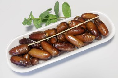 Hurmalar, plastik kutuya doldurulmuş, satılmaya hazır, beyaz arka plan. İş konsepti. Yakın plan..