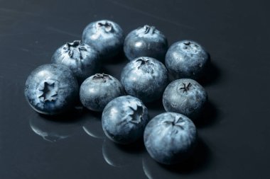 Yaban mersinli yakın çekim, karanlık bir arka planda izole edilmiş, yemeye hazır, vegan yemeği..
