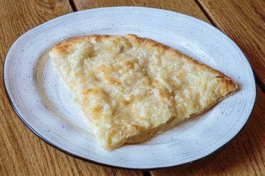 Peynirli büyük bir dilim pizza. Peynirli sıcak tortilla, Khachapuri, Kafkas mutfağı.