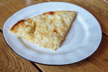 Peynirli büyük bir dilim pizza. Peynirli sıcak tortilla, Khachapuri, Kafkas mutfağı.