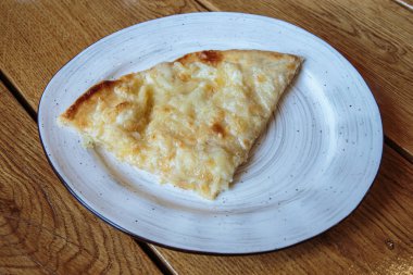 Peynirli büyük bir dilim pizza. Peynirli sıcak tortilla, Khachapuri, Kafkas mutfağı.