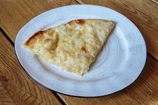 Peynirli büyük bir dilim pizza. Peynirli sıcak tortilla, Khachapuri, Kafkas mutfağı.