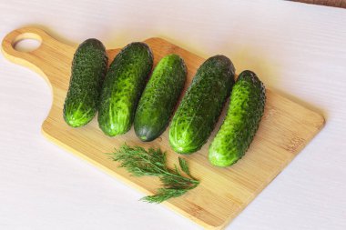 Kesme tahtasındaki taze salatalıklar. Çiftçi pazarından taze ürünler..