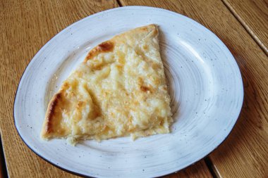 Peynirli büyük bir dilim pizza. Peynirli sıcak tortilla, Khachapuri, Kafkas mutfağı.