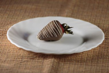 Sütlü çikolatayla kaplı çilekler, işadamları için lezzetli bir tatlı..