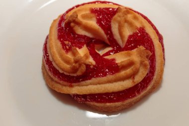 Beyaz bir tabakta çilekli kurabiye.