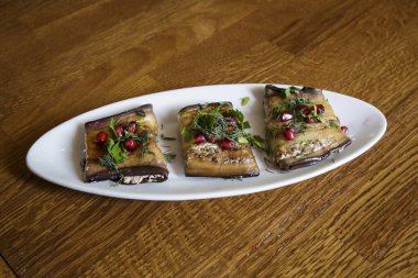 Patlıcan rulosu, fındık, peynir, nar tohumu, baharatlı otlar ve beyaz sarımsak sosuyla pişirilmiş. Vejetaryen yemekleri ve dengeli yemekler..