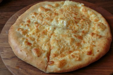 Masadaki ahşap tabakta taze peynirli pizza İtalyan geleneksel aperatifi, yüksek açı manzaralı..