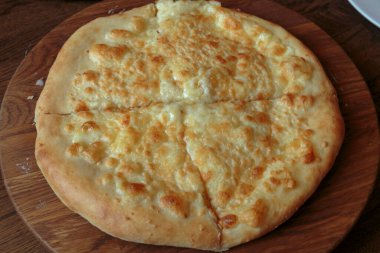 Masadaki ahşap tabakta taze peynirli pizza İtalyan geleneksel aperatifi, yüksek açı manzaralı..