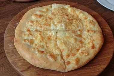 Masadaki ahşap tabakta taze peynirli pizza İtalyan geleneksel aperatifi, yüksek açı manzaralı..