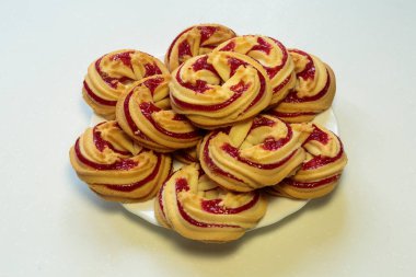 Beyaz tabakta çilekli kurabiyeler, beyaz arka planda çilekli kurabiyeler..