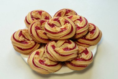 Beyaz tabakta çilekli kurabiyeler, beyaz arka planda çilekli kurabiyeler..