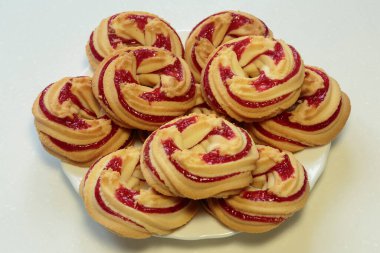 Beyaz tabakta çilekli kurabiyeler, beyaz arka planda çilekli kurabiyeler..