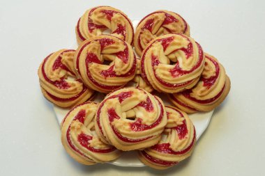 Beyaz tabakta çilekli kurabiyeler, beyaz arka planda çilekli kurabiyeler..