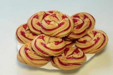 Beyaz tabakta çilekli kurabiyeler, beyaz arka planda çilekli kurabiyeler..