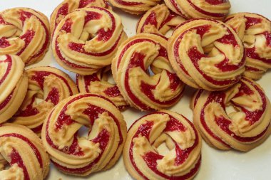 Beyaz arka planda çilek reçelli kurabiyeler..