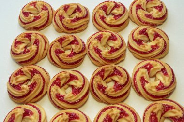 Beyaz arka planda çilek reçelli kurabiyeler..