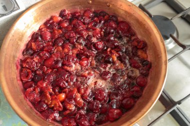 Kaynamış erik reçeli. Bakır leğen kemiğinde erik şurubu ve şeker karışımı pişiyor..