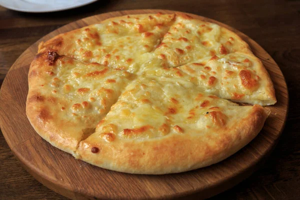 Masadaki ahşap tabakta taze peynirli pizza İtalyan geleneksel aperatifi, yüksek açı manzaralı..
