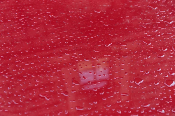 Drops of rain on the car hood. Abstract background.
