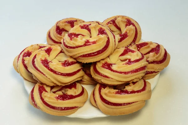 Beyaz tabakta çilekli kurabiyeler, beyaz arka planda çilekli kurabiyeler..
