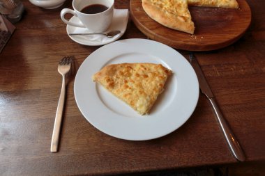 Lokantada beyaz tabakta dilimlenmiş peynirli pizza, İtalyan geleneksel aperatifi..