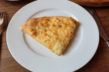 Lokantada beyaz tabakta dilimlenmiş peynirli pizza, İtalyan geleneksel aperatifi..