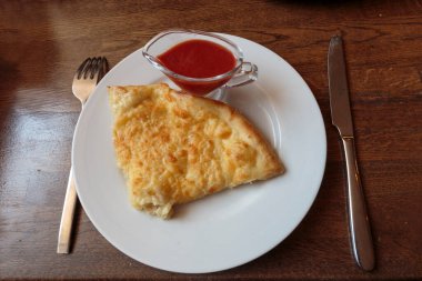 Lokantada beyaz tabakta dilimlenmiş peynirli pizza, İtalyan geleneksel aperatifi..