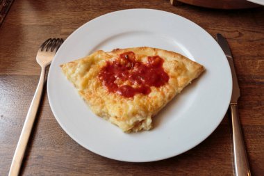 Lokantada beyaz tabakta dilimlenmiş peynirli pizza, İtalyan geleneksel aperatifi..