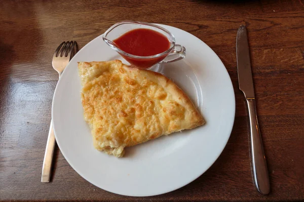 Lokantada beyaz tabakta dilimlenmiş peynirli pizza, İtalyan geleneksel aperatifi..