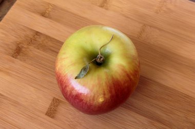 Tahta arka planda izole edilmiş sulu elma.
