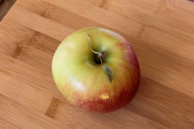 Tahta arka planda izole edilmiş sulu elma.