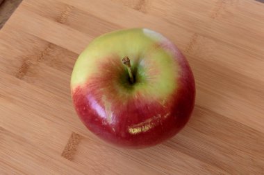 Tahta arka planda izole edilmiş sulu elma.