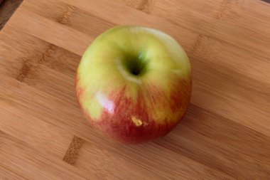 Tahta arka planda izole edilmiş sulu elma.