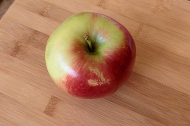 Tahta arka planda izole edilmiş sulu elma.