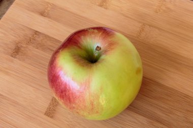 Tahta arka planda izole edilmiş sulu elma.