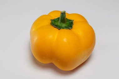 Beyaz arka planda izole edilmiş, su damlalarında sarı tatlı biber. Vejetaryen yemeği.