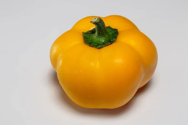 Yellow sweet pepper in drops of water, isolated on white background. Vegan food.