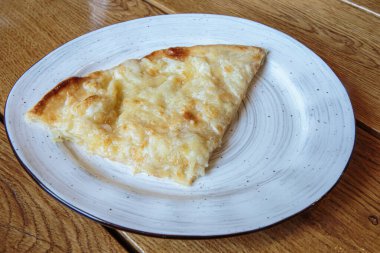Peynirli büyük bir dilim pizza. Peynirli sıcak tortilla, Khachapuri, Kafkas mutfağı.