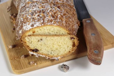 Kesme tahtasında ceviz ve kuru üzümlü kek. Pudra şekeri ve ezilmiş ceviz serpiştirilmiş..