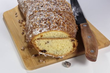 Kesme tahtasında ceviz ve kuru üzümlü kek. Pudra şekeri ve ezilmiş ceviz serpiştirilmiş..