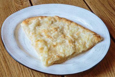 Peynirli büyük bir dilim pizza. Peynirli sıcak tortilla, Khachapuri, Kafkas mutfağı.