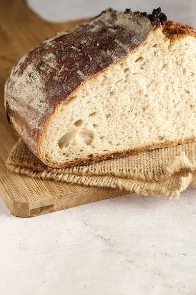 Bir somun sade ekşi ekmek tahtada ikiye bölünmüş