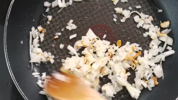 Ξύλινη Κουτάλα Ανακατεύοντας Σκόρδο Και Κρεμμύδι Σοταρισμένο Τηγάνι — Αρχείο Βίντεο