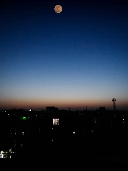 日落时分 月亮横过城市 蓝天映衬 — 图库照片