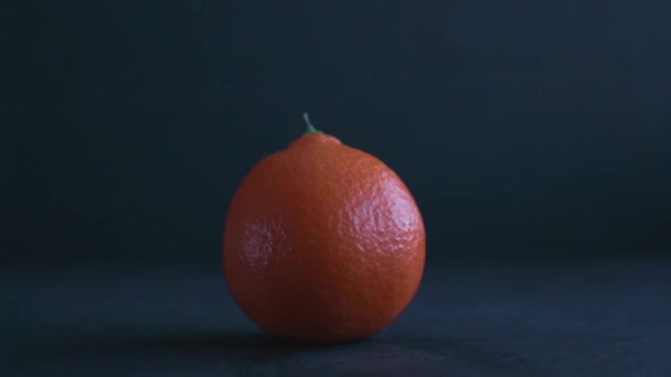 Nahaufnahme Einer Porösen Und Leuchtend Orangen Mandarine Auf Einer Dunkelblauen — Stockvideo