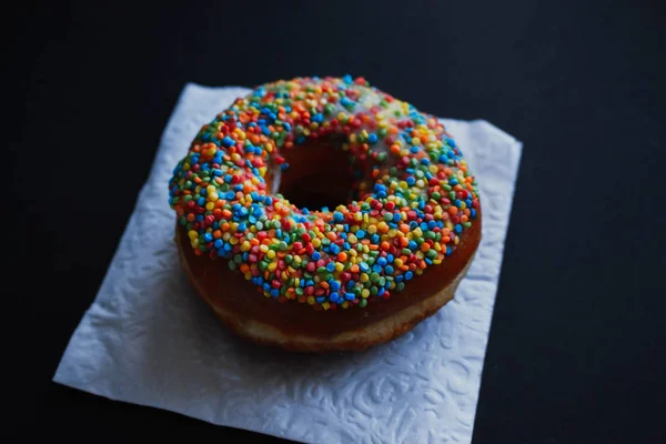 Vista próxima em saborosos donuts em um fundo escuro — Fotografia de Stock