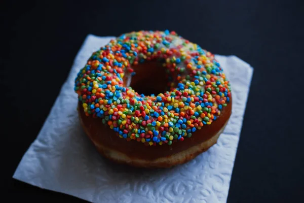 Близкий вид на вкусные пончики на темном фоне — стоковое фото