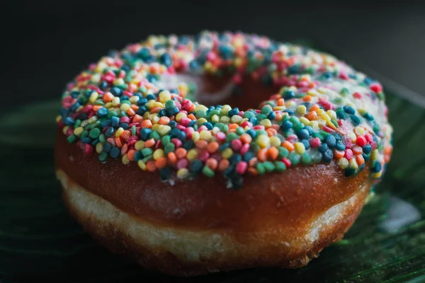 Vista próxima em saborosos donuts em um fundo escuro — Fotografia de Stock